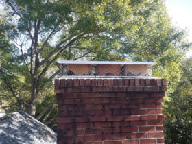 A chimney with a chimney cap on top of it, providing chimney services.