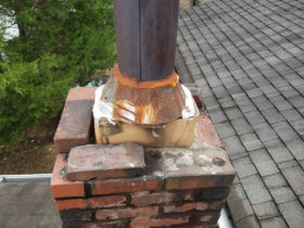 A rusty chimney with a metal piece.