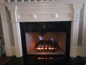 A fireplace with a white mantle and blue flames.