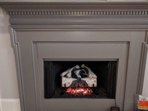 A fireplace mantle with a fire in it.