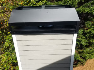 The top of a metal shed with a black roof used for chimney and dryer vent services.
